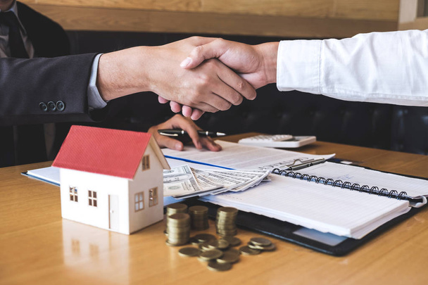 Obraz z udanej transakcji nieruchomości, pośrednik i drżenie rąk po podpisaniu umowy klient zatwierdzony formularz wniosku, dotyczące oferty kredytowej kredytu hipotecznego dla i ubezpieczenie domu. - Zdjęcie, obraz