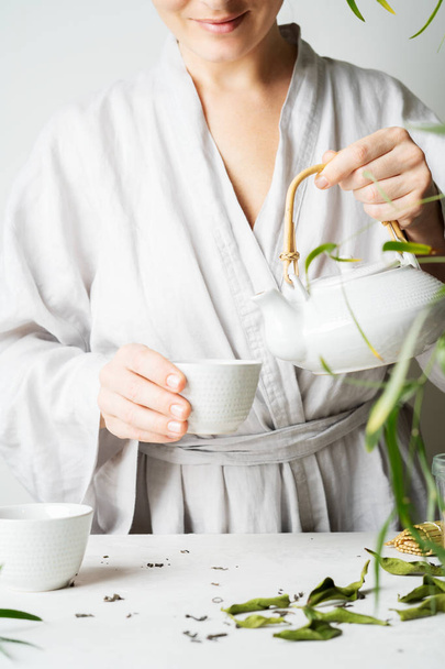 Woman pouring tea from teapot to teacup on tea ceremony  - Foto, immagini