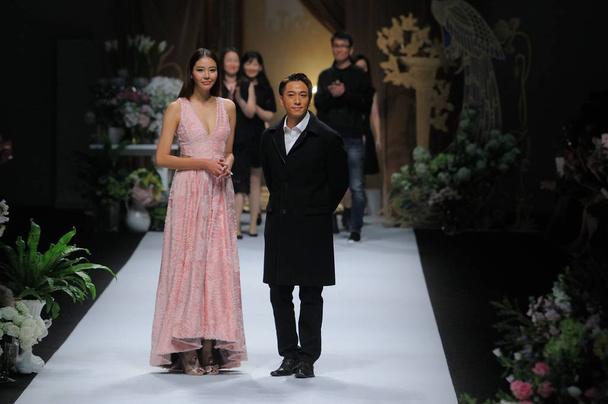 Chinese model Luo Zilin, left, and Hong Kong actor Ron Ng display new creations at the Prolivon fashion show during the Shanghai Fashion Week Fall/Winter 2016 in Shanghai, China, 9 April 2016. - Valokuva, kuva