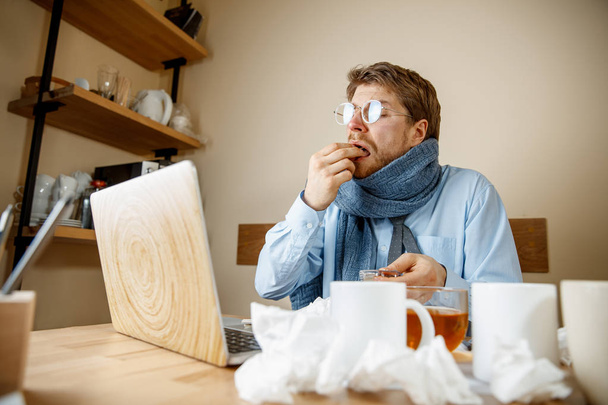 Sick man while working in office, businessman caught cold, seasonal flu. - Foto, Bild