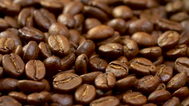 Shiny and fragrant brown roasted coffee beans on a rotating panel. Background close-up, UHD - Video
