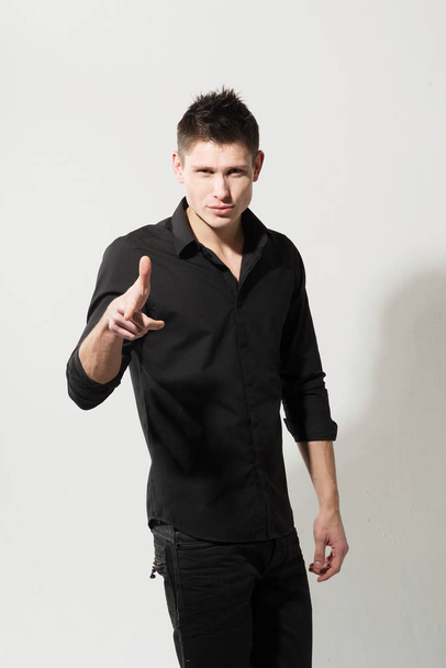 Portrait of young caucasian man in black shirt posing on white background - Foto, Imagen