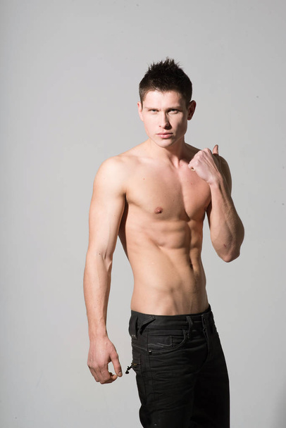 Nuoren valkoihoisen miehen muotokuva, jolla on vahva lihaksikas vartalo valkoisella taustalla
 - Valokuva, kuva