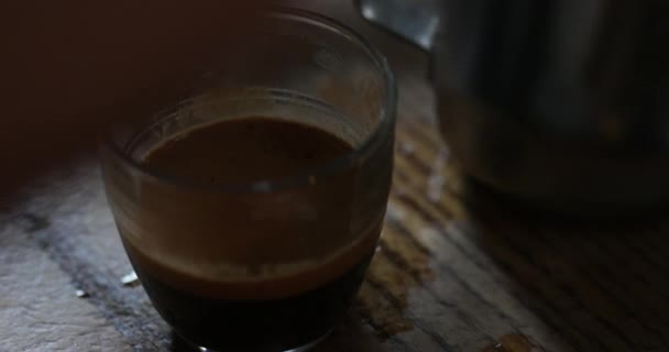 Close-up view of a unrecognisable person picking up a cup of coffee and mixing it before pouring milk into it. - Imágenes, Vídeo