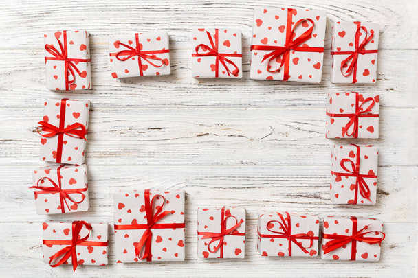 Rahmen aus vielen bunten Geschenkboxen mit roter Schleife und Herz leer Kopierraum Draufsicht, Valentinstag oder andere Feiertage Konzept. - Foto, Bild