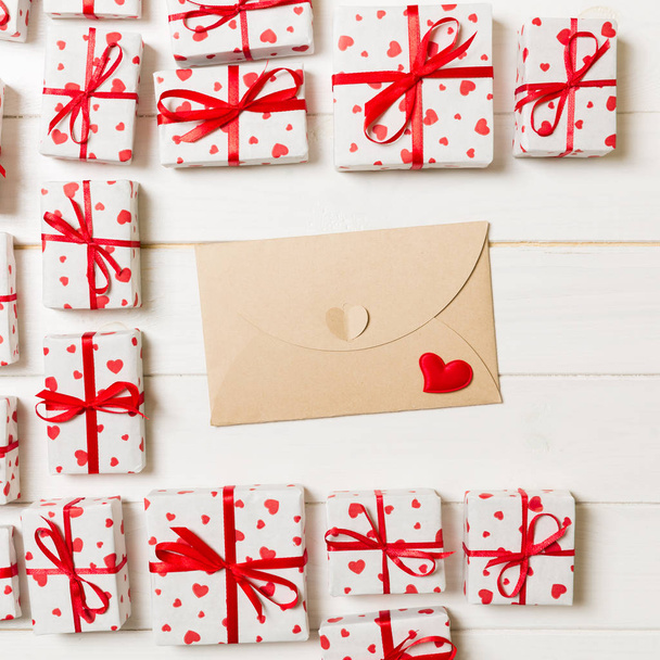 Día de San Valentín fondo romántico. tarjeta de sobre con cajas de regalo y corazón sobre un fondo de madera
. - Foto, imagen