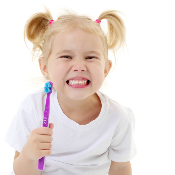 A little girl brushes her teeth. - Фото, зображення