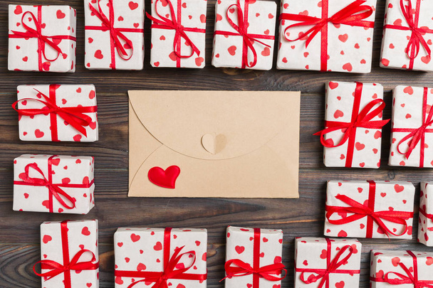 Boríték levél piros szív és ajándék doboz fa háttér felett. Valentin-napi üdvözlőlap, szeretet, vagy esküvői köszöntő koncepció kialakítása. - Fotó, kép