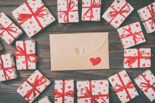 Valentines day mock up. envelope in gift boxes frame on wooden vintage toned background. Valentines day card concept. - Fotó, kép