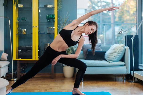 Donna che pratica yoga a casa. - Foto, immagini