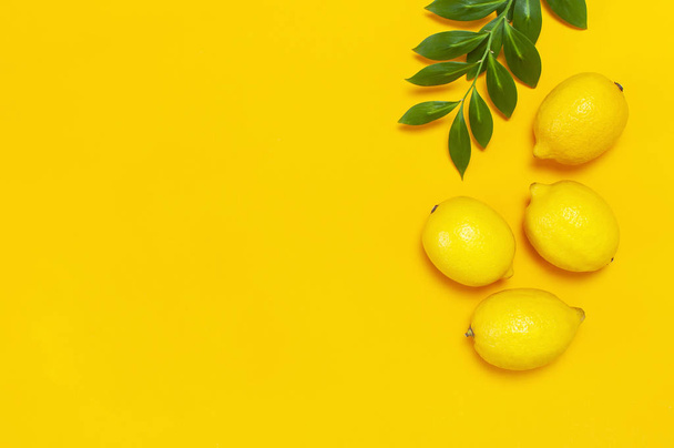 Citrons juteux mûrs et feuilles vertes sur fond jaune vif. Citronnelle, agrumes concept minimal, vitamine C. Alimentation estivale créative fond minimaliste. Pose plate, vue du dessus, espace de copie
 - Photo, image