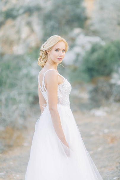 Bride in the mountains with a beautiful view of Cyprus. A wedding dress and a happy girl. - Foto, Bild