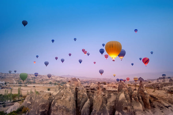 Γκρο πλαν πολύχρωμα μεγάλα αερόστατα πετώντας πάνω από το όμορφο τοπίο του χωριού Goreme στην Ανατολή του ηλίου. Καππαδοκίας είναι διάσημος ταξιδιωτικός προορισμός με όμορφα καταπράσινα βουνά, Τουρκία - Φωτογραφία, εικόνα