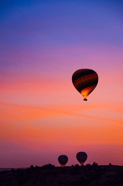 Γκρο πλαν πολύχρωμα μεγάλα αερόστατα πετώντας πάνω από το όμορφο τοπίο του χωριού Goreme στην Ανατολή του ηλίου. Καππαδοκίας είναι διάσημος ταξιδιωτικός προορισμός με όμορφα καταπράσινα βουνά, Τουρκία - Φωτογραφία, εικόνα