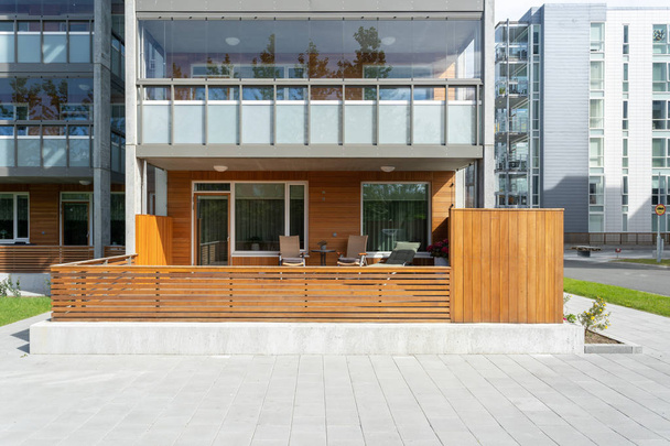 Foto de acogedor porche de entrada con terraza vacía, silla de madera y mesa en la casa de la ciudad moderna
 - Foto, imagen
