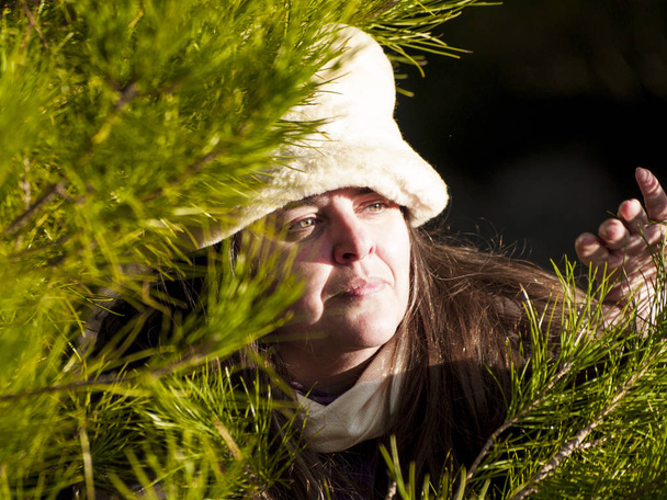  woman white hat posing next to tree - Foto, afbeelding