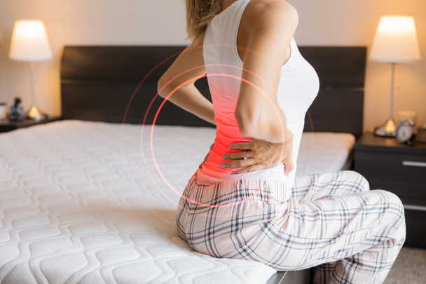 Woman suffering from back pain because of uncomfortable mattress - Φωτογραφία, εικόνα