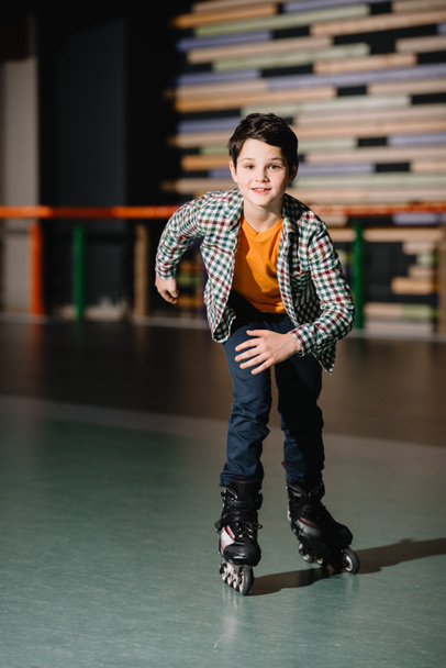 Foco seletivo de bonito sorrindo menino patinação em rolos
  - Foto, Imagem