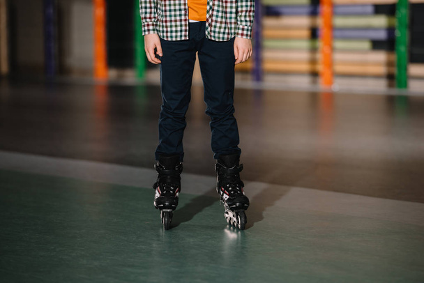 Partial view of boy in roller skates standing in roller rink - 写真・画像