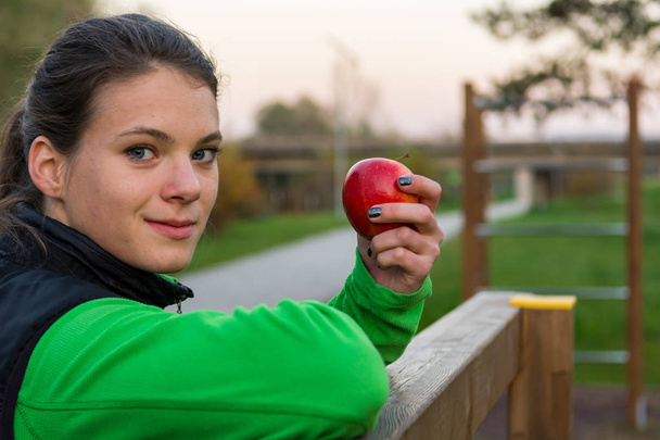 Sportliche Frau mit gesundem Obst-Snack beim Sport im Freien. - Foto, Bild