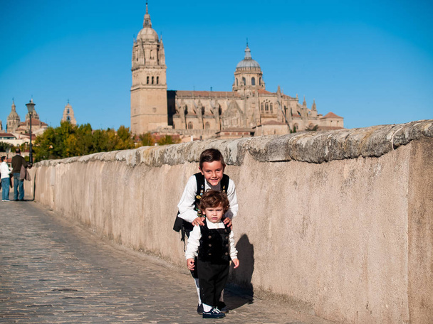 Two  brothers on the Roman bridge of Salamanca, dressed in traditional clothes - Photo, Image