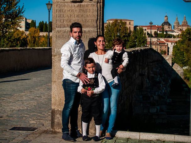 Salamanca Köprüsü 'nde geleneksel kıyafetler giymiş iki kardeş ve anne baba. - Fotoğraf, Görsel