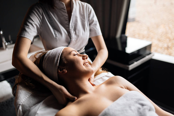 Beautiful young woman enjoying massage and rejuvenating - Fotoğraf, Görsel