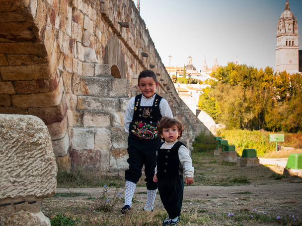 Dwoje dzieci braci na Roman bridge Salamanca, ubrani w tradycyjne stroje i Katedra w Salamance - Zdjęcie, obraz