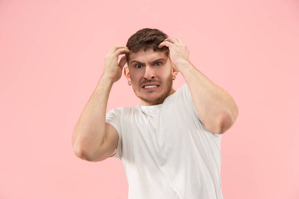 Beautiful man looking suprised and bewildered isolated on pink - Foto, afbeelding