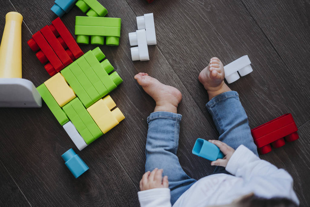 Счастливый ребенок играет с игрушечными блоками в доме
. - Фото, изображение