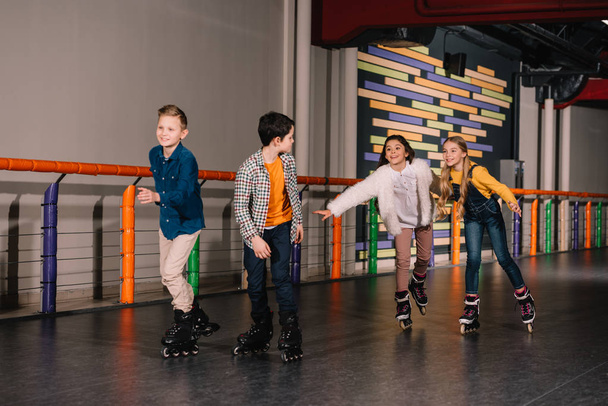 Laughing kids in roller skates enjoying leisure - Foto, Imagen