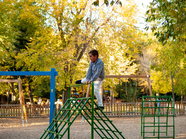  kleine jongen spelen op de speelplaats - Foto, afbeelding