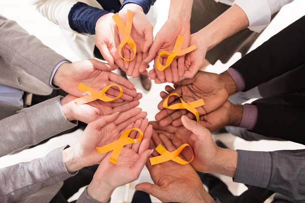 Groupe de gens d'affaires tenant des rubans de sarcelle pour soutenir l'enfance et le cancer de la vessie
 - Photo, image