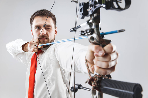 Businessman aiming at target with bow and arrow, isolated on white background - Photo, Image