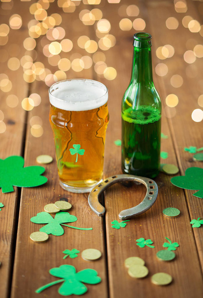 glass of beer, bottle, horseshoe and gold coins - 写真・画像