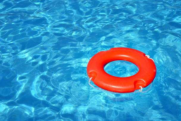 Colorido tubo salvavidas flotando en la piscina, concepto de vacaciones de verano
 - Foto, imagen
