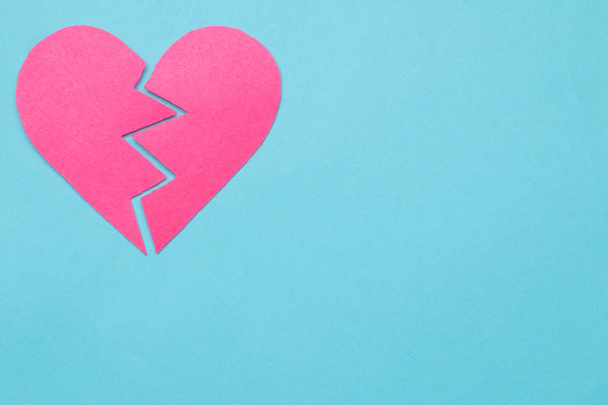 Разбитое розовое сердце на ярко-голубом фоне. сломанная любовь с пространством для текста
 - Фото, изображение