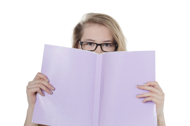 μια γυναίκα που κρατά το βιβλίο που καλύπτουν το πρόσωπό - Φωτογραφία, εικόνα