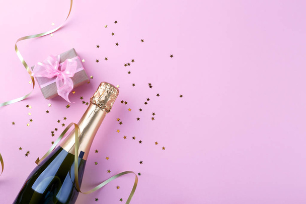 Colocação plana de composição Garrafa de champanhe e confete no espaço de cópia de fundo rosa - Foto, Imagem
