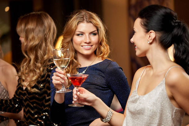 happy women clinking glasses at night club - Photo, Image