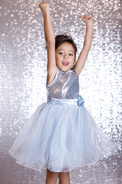 cute smiling little child girl in silver and blue dress - 写真・画像