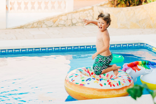 Funny little boy jumpping into the pool, summer activities for children - Photo, Image