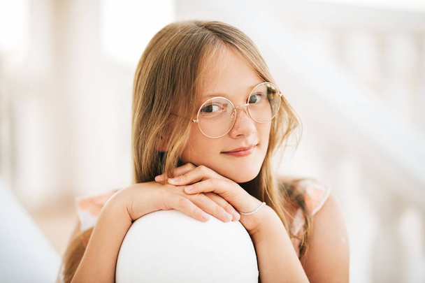 Retrato al aire libre de una hermosa joven con gafas, inclinada de la cabeza en las manos, imagen de cerca
 - Foto, imagen