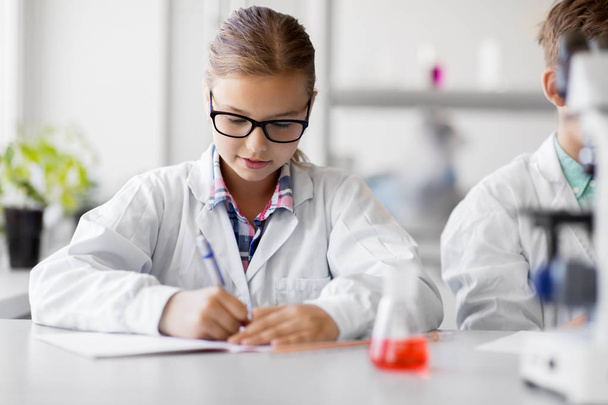 girl studying chemistry at school laboratory - Foto, afbeelding