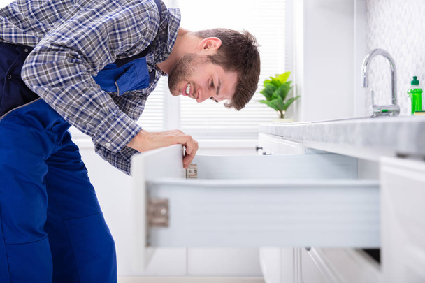 Close-up Of A Male Carpenter Installing Door Of Drawer In The Kitchen - Foto, Bild