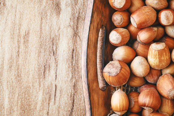 Čerstvé zralé bio lískové ořechy (ořech) v dřevěné misce. Pohled shora s kopií prostor - Fotografie, Obrázek