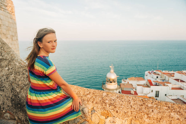 Little girl on the top of Peniscola, admiring amazing summer sunset, travel with children, wearing colorful dress - Photo, Image