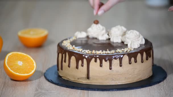 Female hand decorated the cake with chopped hazelnuts - Footage, Video
