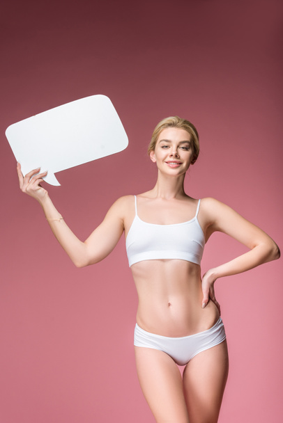 happy woman in white underwear posing with speech bubble, isolated on pink - Fotografie, Obrázek