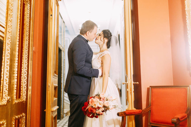 Meeting the newlyweds in the Studio and hotel. Bride and groom with a bouquet. - Zdjęcie, obraz